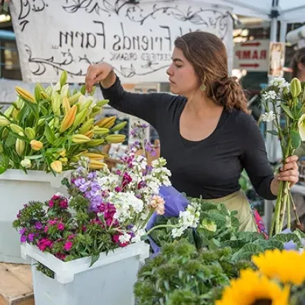 A vendor selling fresh-cut flowers at a farmer's market in downtown 北安普顿.